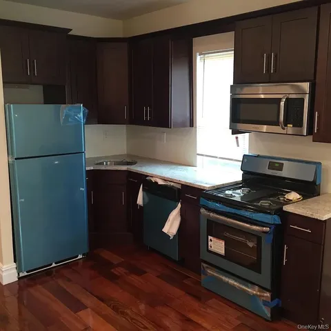 a kitchen with granite countertop wooden cabinets and stainless steel appliances