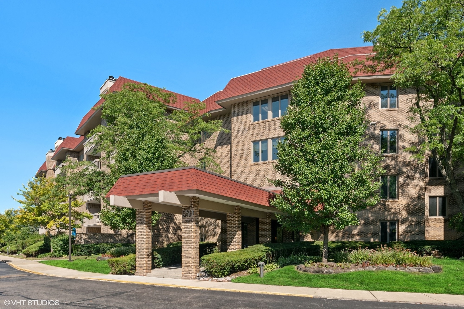 a front view of a house with a yard and trees