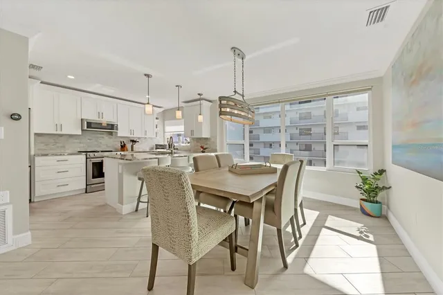 a kitchen with a table chairs refrigerator and cabinets