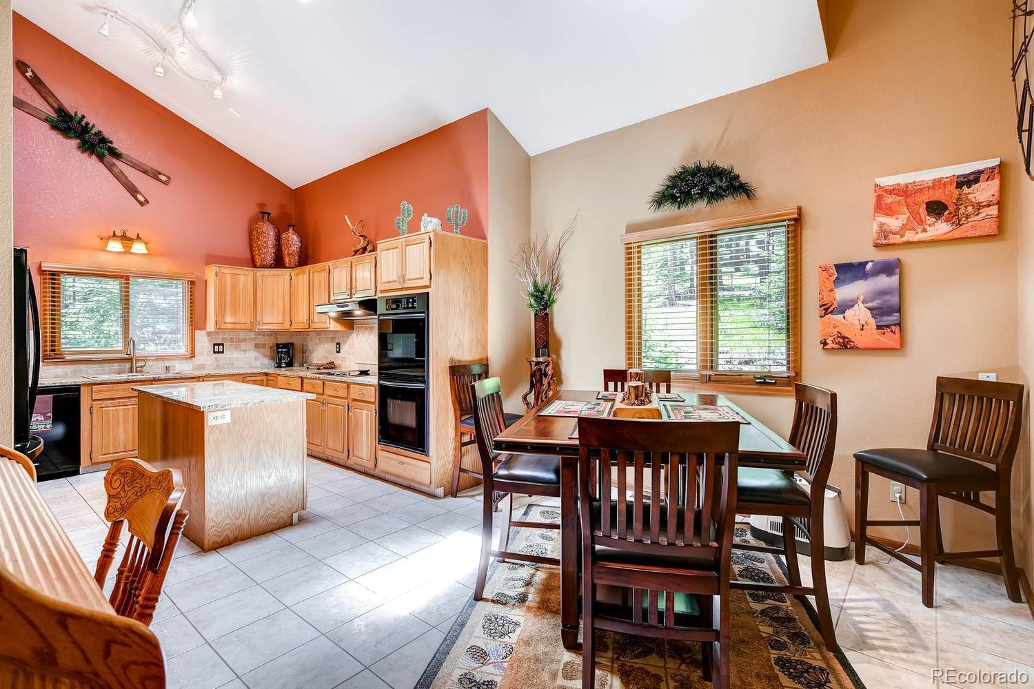 8045 Native Dancer Trail Evergreen, CO 80439 - Photo 11 of 29 a dining room with furniture a rug and a view of kitchen