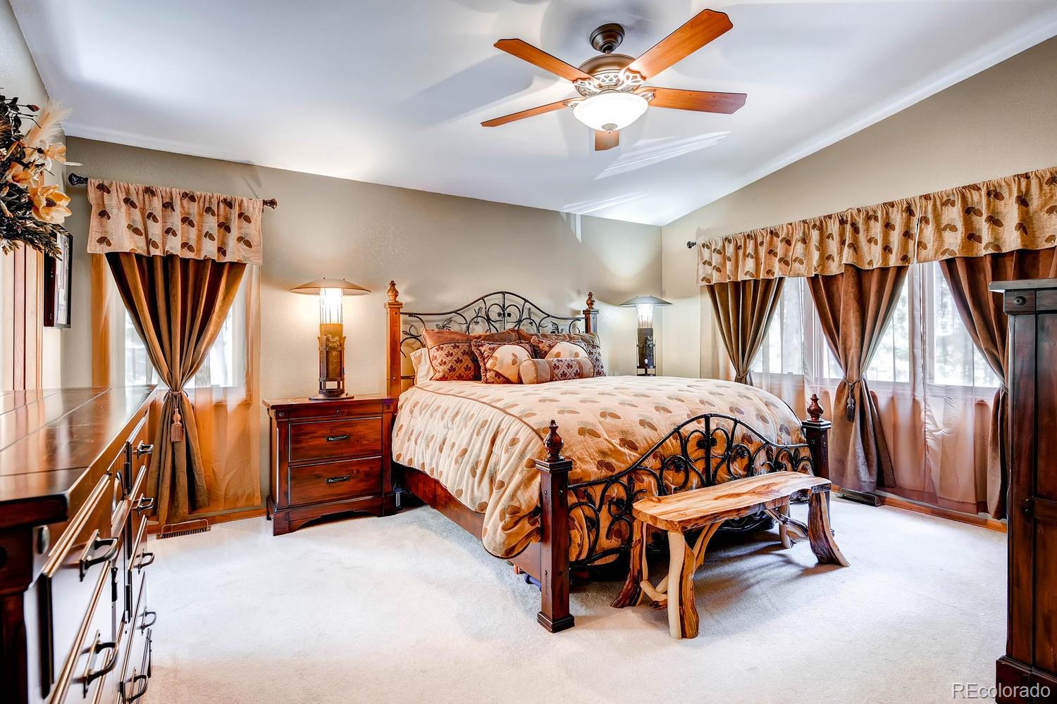 8045 Native Dancer Trail Evergreen, CO 80439 - Photo 12 of 29 a bedroom with a bed and a chandelier