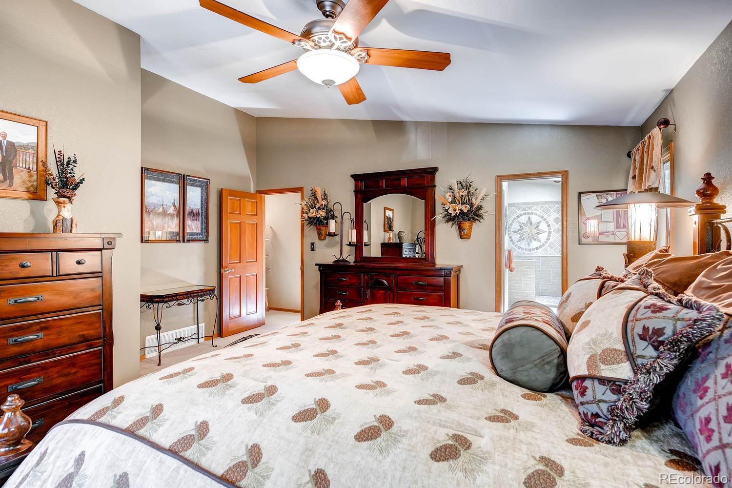 8045 Native Dancer Trail Evergreen, CO 80439 - Photo 13 of 29 a bedroom with a bed and dresser with mirror