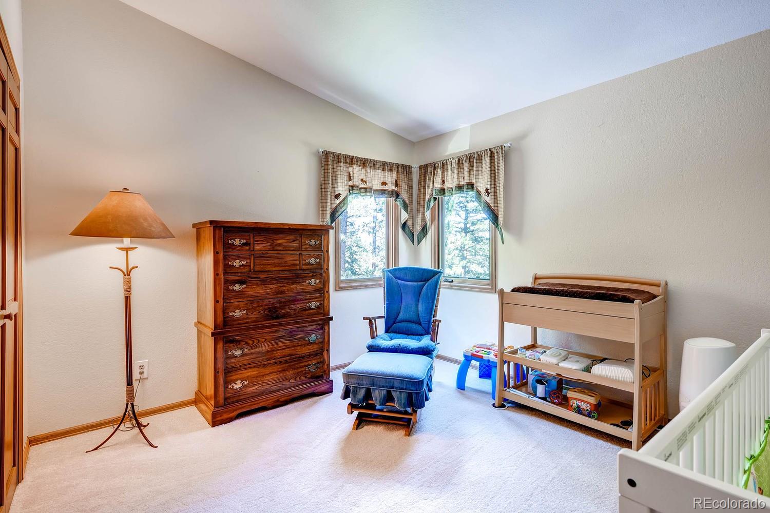 8045 Native Dancer Trail Evergreen, CO 80439 - Photo 17 of 29 a bedroom with furniture and a lamp