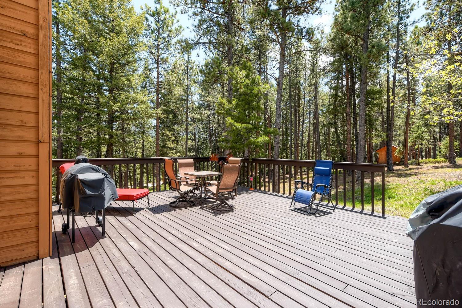 8045 Native Dancer Trail Evergreen, CO 80439 - Photo 26 of 29 a balcony with wooden floor and outdoor seating
