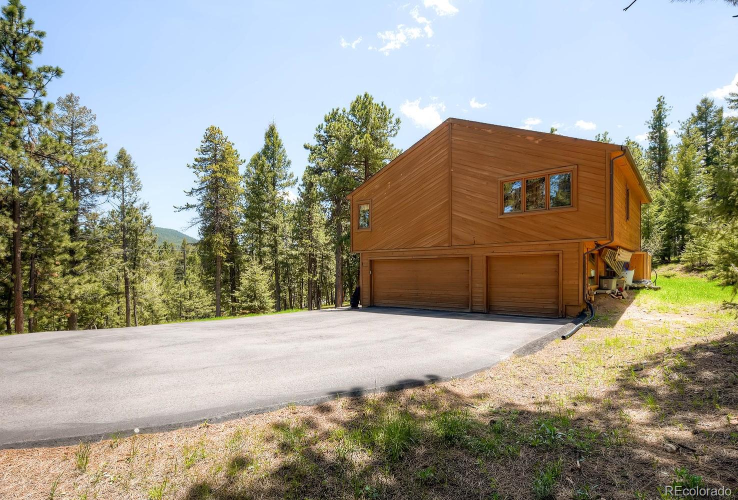 8045 Native Dancer Trail Evergreen, CO 80439 - Photo 29 of 29 a front view of a house with a yard and garage