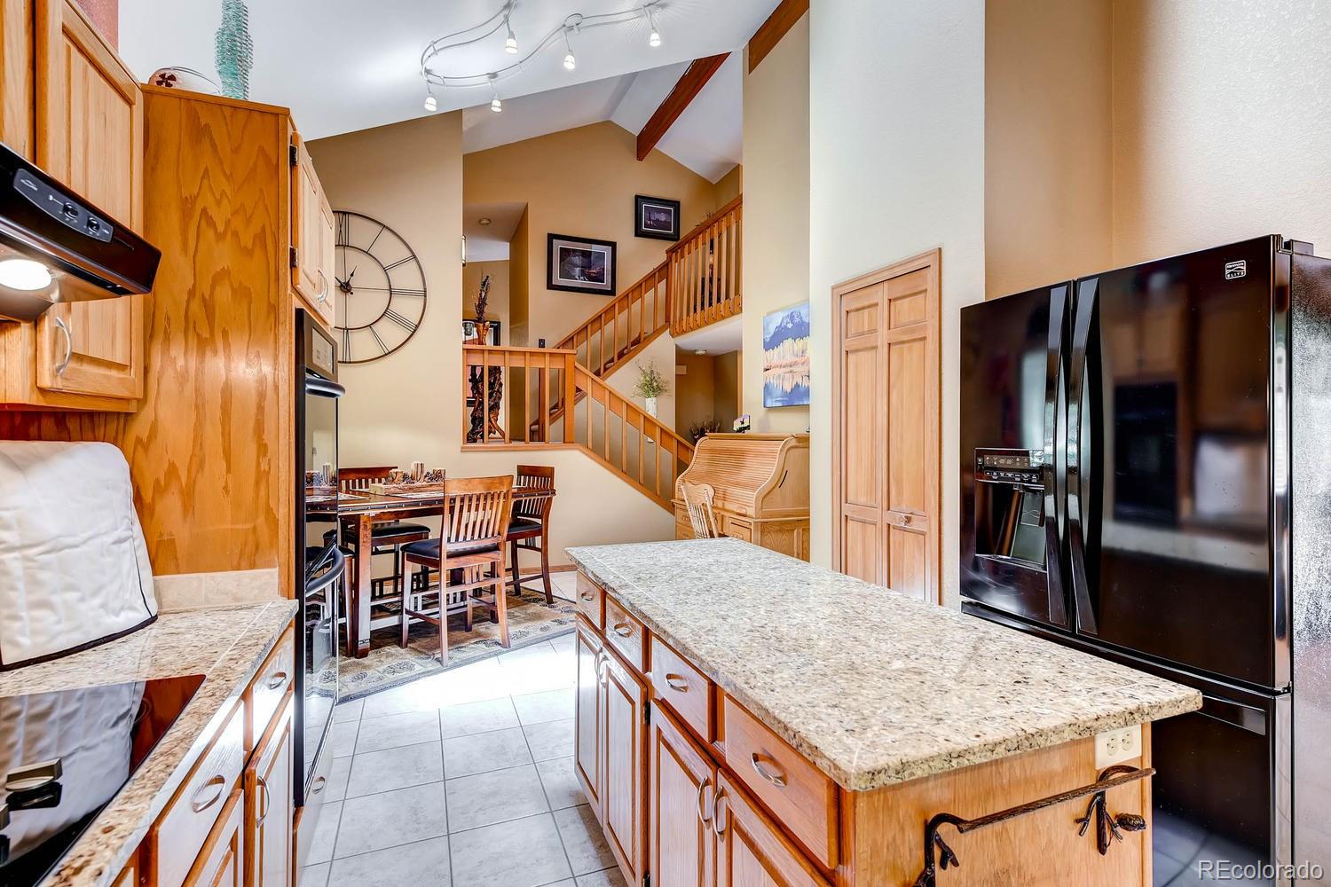 8045 Native Dancer Trail Evergreen, CO 80439 - Photo 9 of 29 a kitchen with stainless steel appliances granite countertop table and chairs