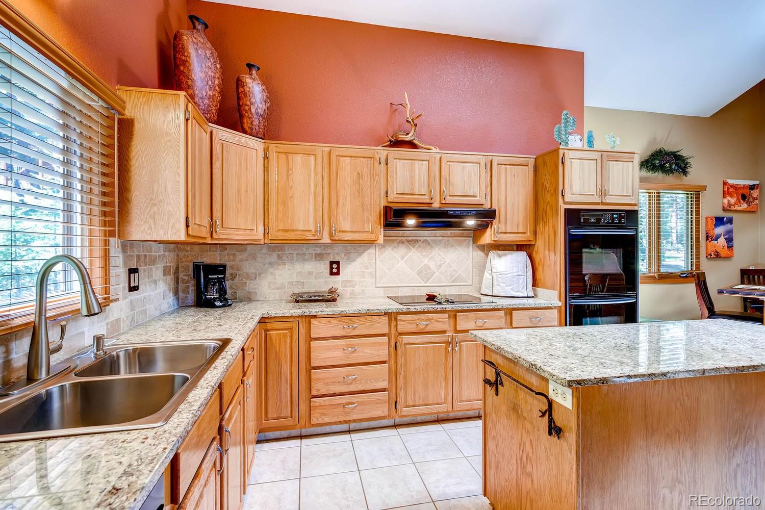 8045 Native Dancer Trail Evergreen, CO 80439 - Photo 10 of 29 a kitchen with stainless steel appliances granite countertop a sink stove and refrigerator
