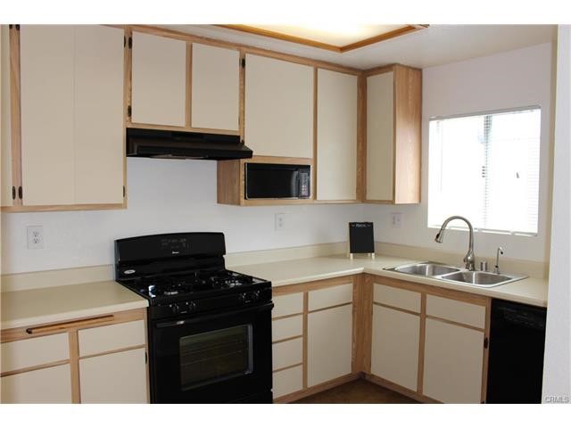 24202 Sylvan Glen Road, Unit F Diamond Bar, CA 91765 - Photo 5 of 8 a kitchen with stainless steel appliances a sink dishwasher stove and cabinets