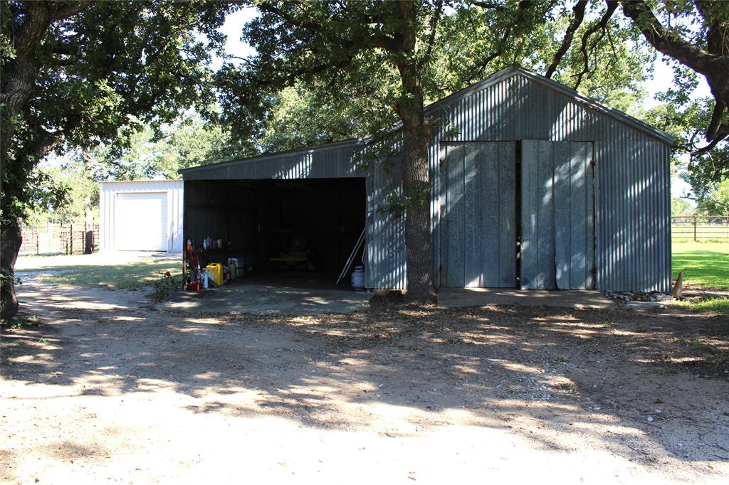 5050 Highway 67, Unit 377N Comanche, TX 76442 - Photo 23 of 30 a view of a barn house next to a road and large trees