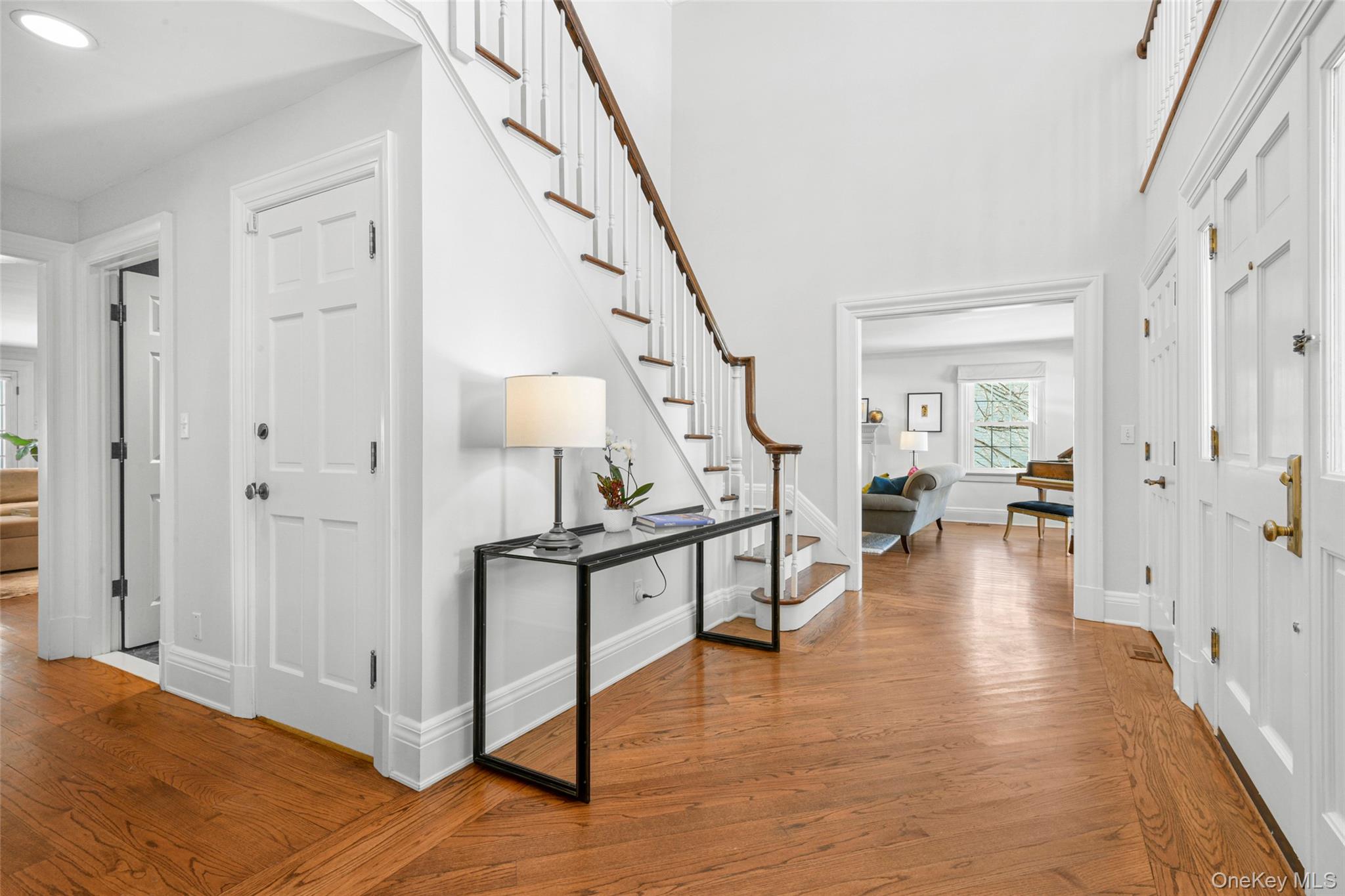 10 Hilltop Road Larchmont, NY 10538 - Photo 4 of 50 View from the foyer into the living room and hallway, with access to the lower level and powder room.