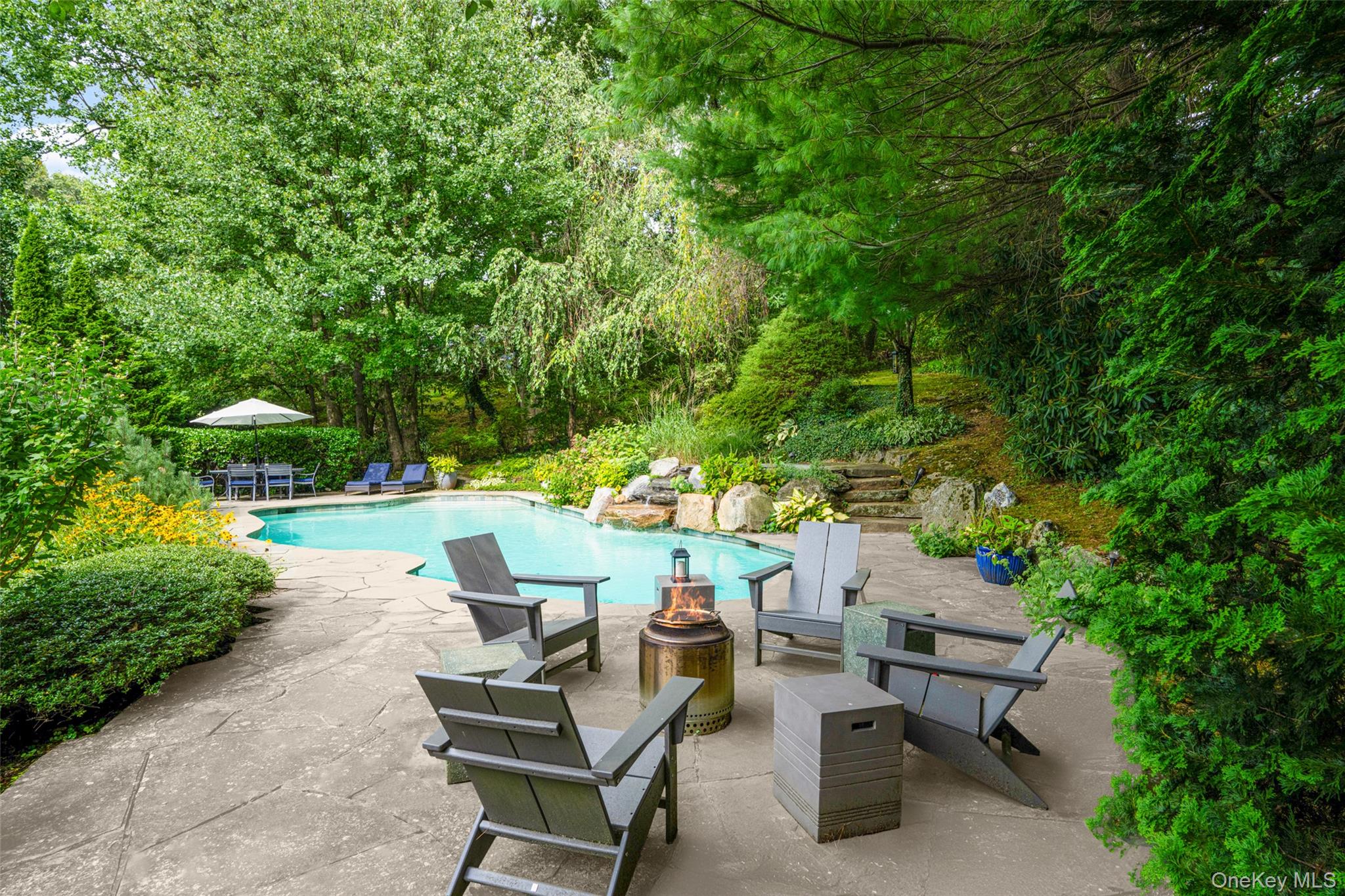 10 Hilltop Road Larchmont, NY 10538 - Photo 42 of 50 Pool area fully fenced, includes a fire pit and dining spaces.