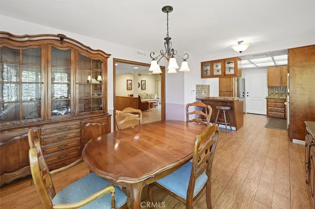 a dining room with furniture a chandelier and wooden floor