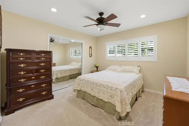 a spacious bedroom with a bed and a dresser