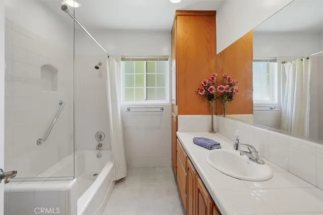 a bathroom with a tub sink and mirror