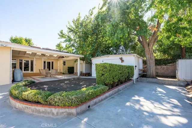 a front view of a house with a yard and potted plants