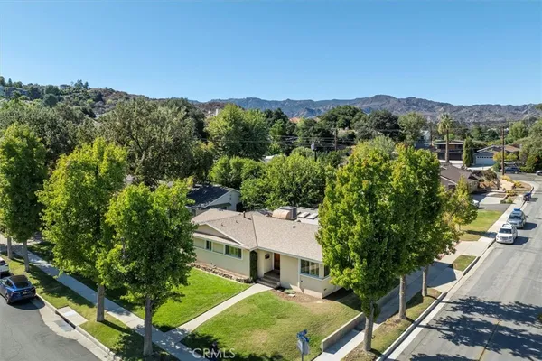 an aerial view of residential houses with outdoor space and trees