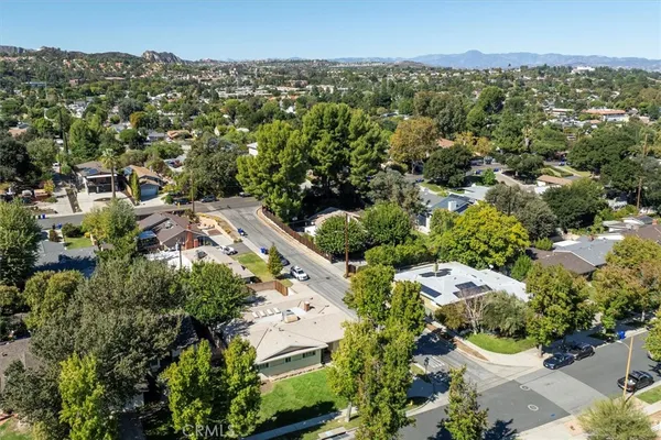an aerial view of residential houses with outdoor space and trees