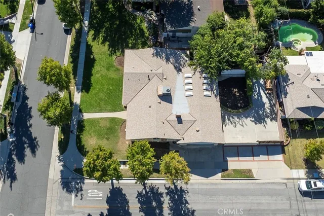 an aerial view of a house with a yard and large tree