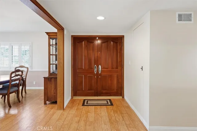 a view of a hallway with wooden floor and furniture