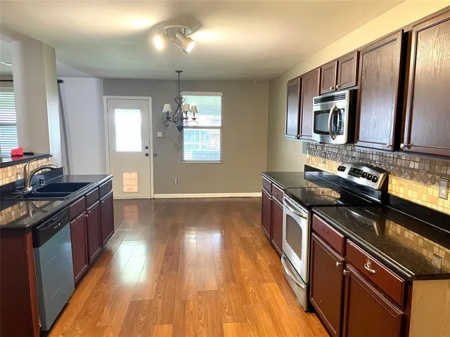 a kitchen with stainless steel appliances granite countertop a stove and a sink