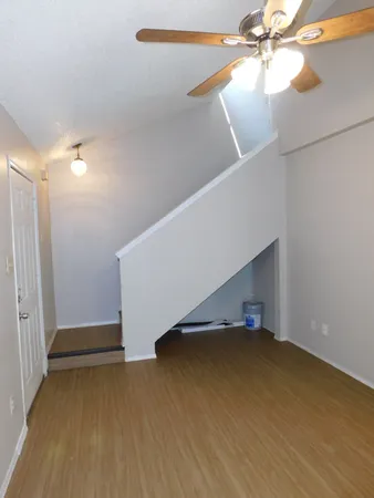 a view of an empty room with wooden floor