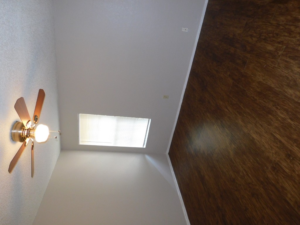 2223 Katy Lane, Unit B Georgetown, TX 78626 - Photo 10 of 11 an empty room with wooden floor fan and windows