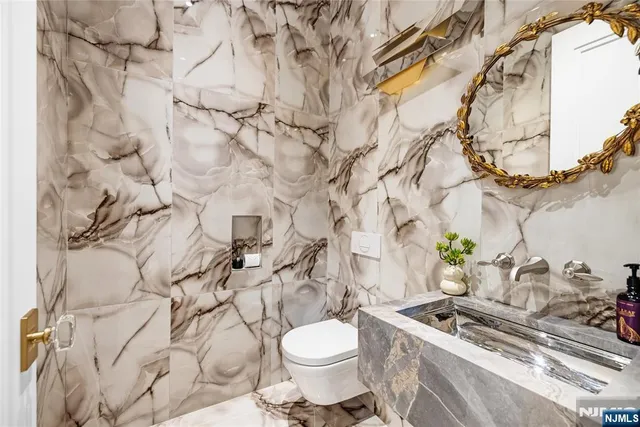 a bathroom with a granite countertop toilet and sink
