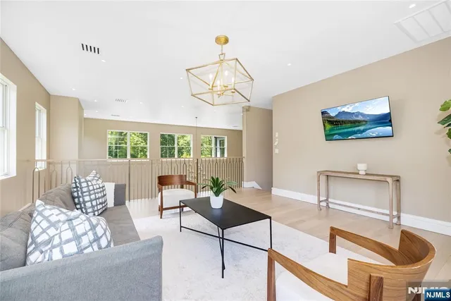a living room with furniture a chandelier and a window