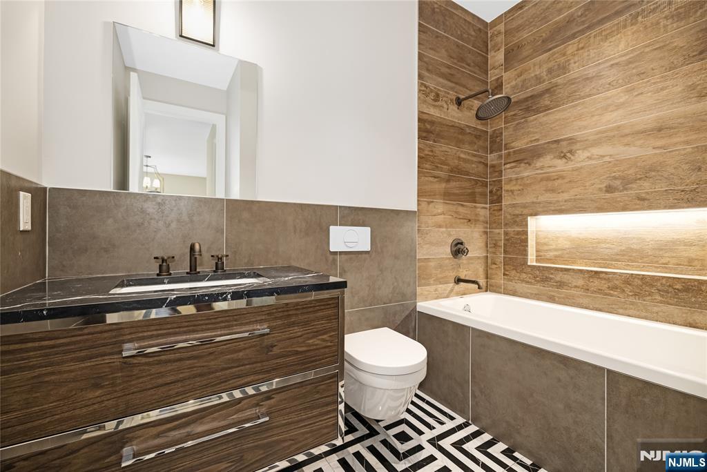 241 East Saddle River Road Saddle River, NJ 07458 - Photo 25 of 48 a bathroom with a granite countertop toilet a sink and a mirror