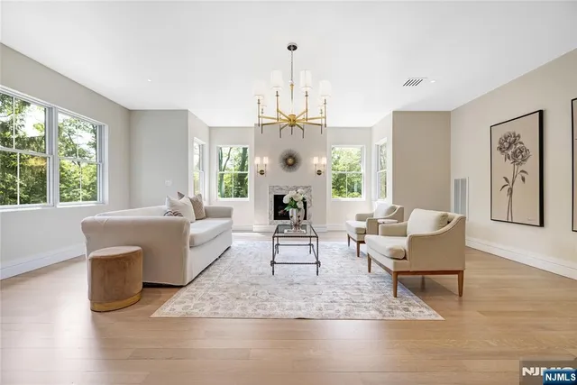a living room with furniture a large window and a chandelier