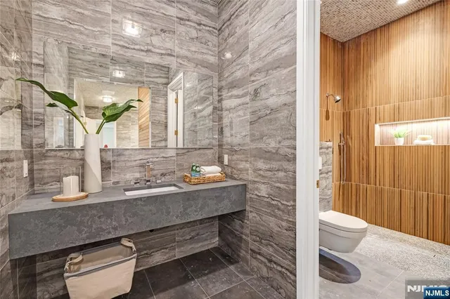 a bathroom with a granite countertop sink a toilet and shower
