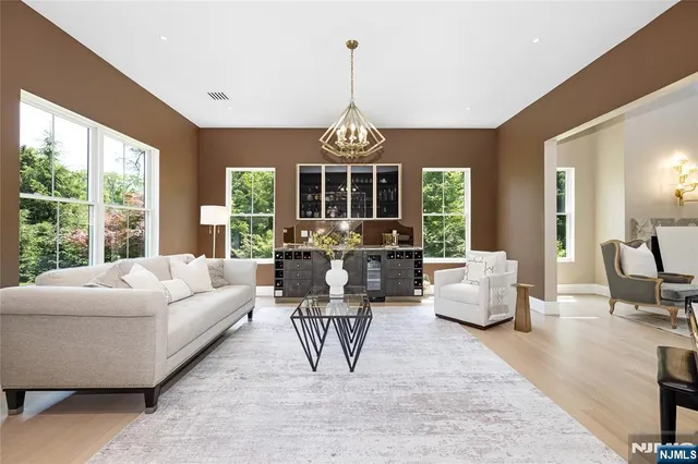 a living room with patio a dining table and a chandelier