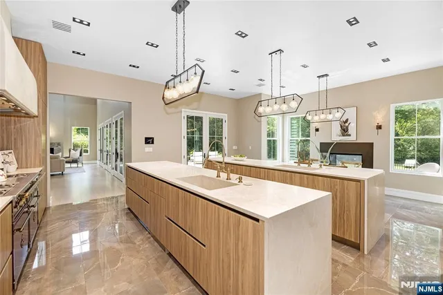 a large kitchen with a counter space a sink appliances and a large window