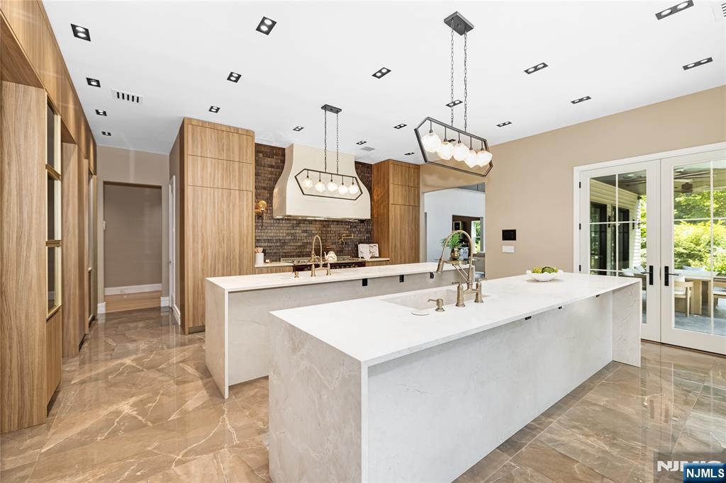 241 East Saddle River Road Saddle River, NJ 07458 - Photo 10 of 48 a large kitchen with a sink a center island a counter space and stainless steel appliances