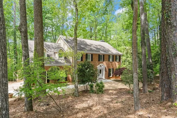 a view of a house with a yard and sitting area