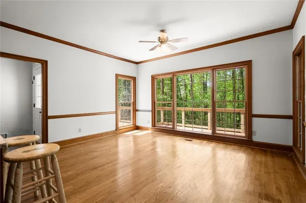 an empty room with wooden floor and a ceiling fan