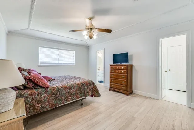 a bedroom with a bed and a flat tv screen on a dresser