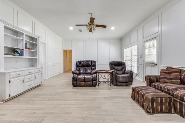 a living room with furniture cabinets and a window