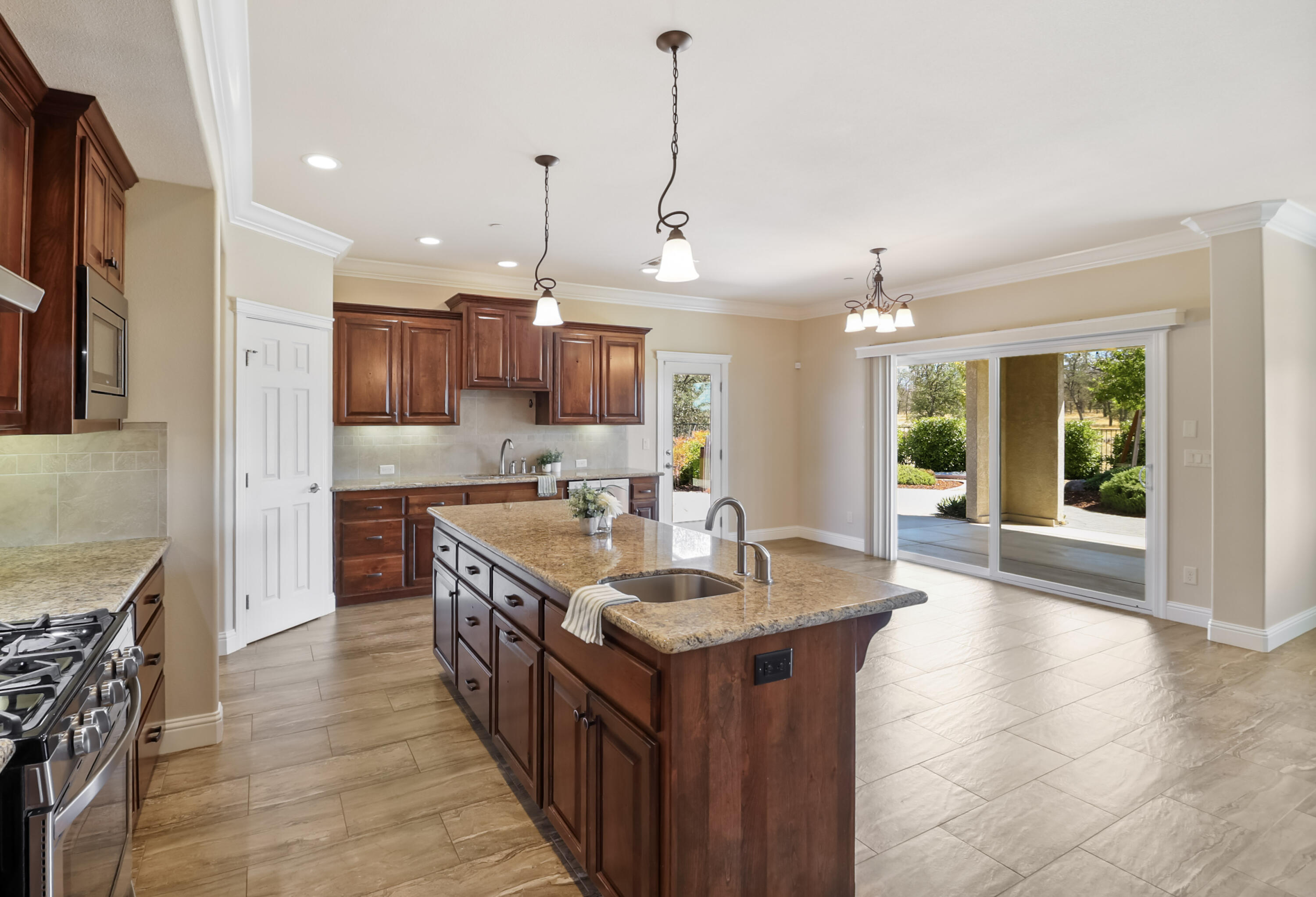 3863 Indian Wells Lane Redding, CA 96002 - Photo 11 of 63 a kitchen with kitchen island granite countertop a sink and a wooden floors