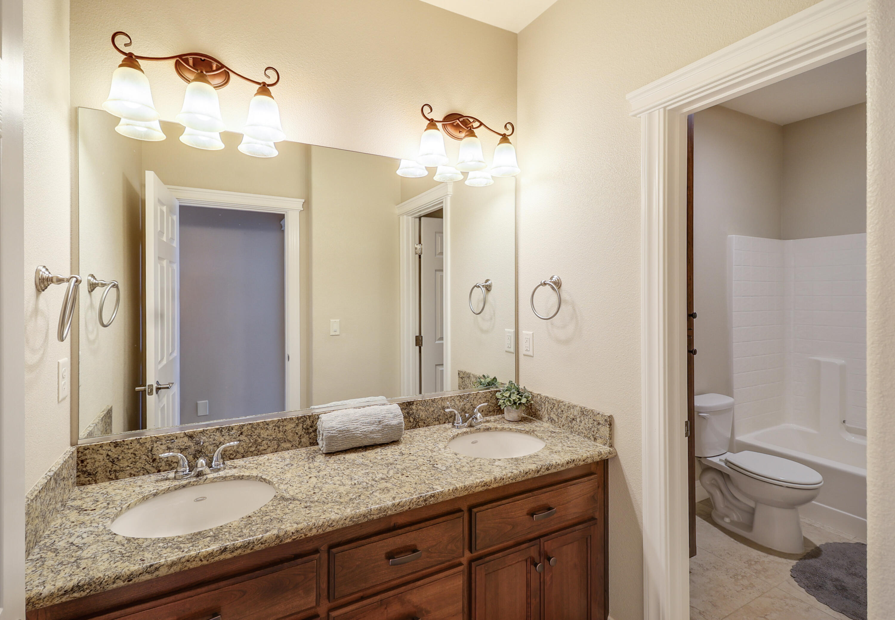 3863 Indian Wells Lane Redding, CA 96002 - Photo 23 of 63 a bathroom with a granite countertop sink a toilet and a mirror