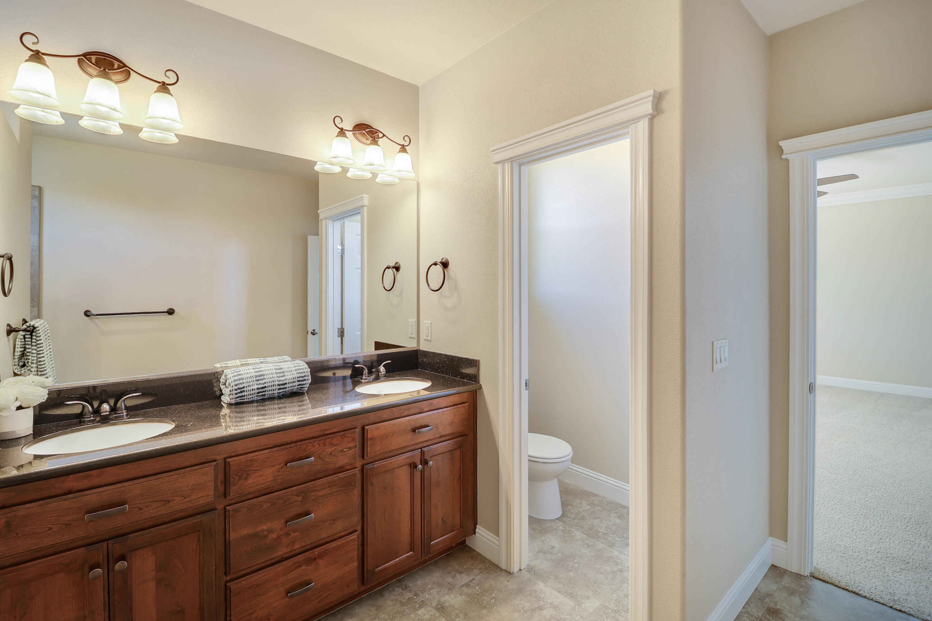 3863 Indian Wells Lane Redding, CA 96002 - Photo 35 of 63 a spacious bathroom with a granite countertop sink a toilet and a mirror