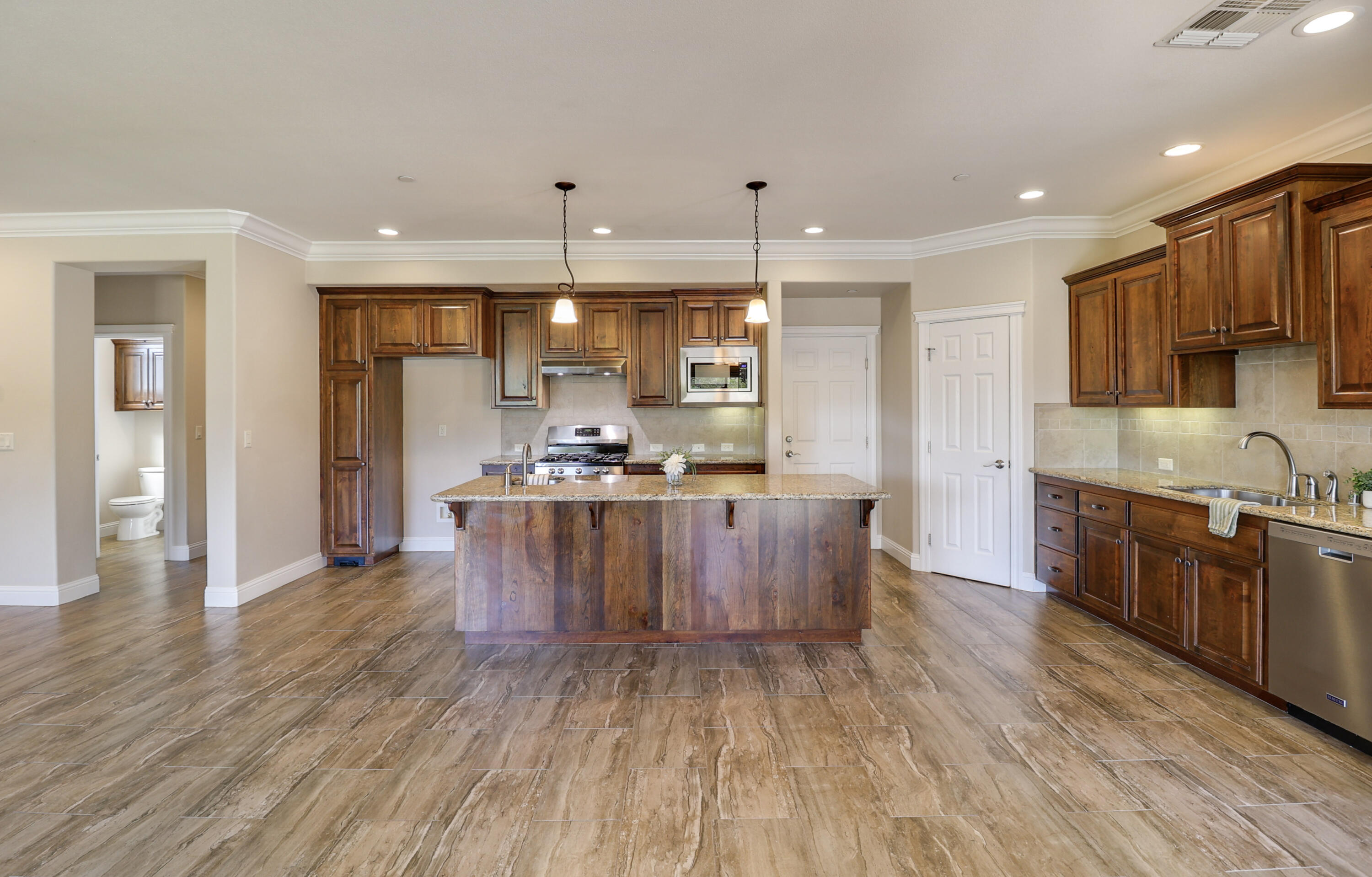 3863 Indian Wells Lane Redding, CA 96002 - Photo 4 of 63 a kitchen with stainless steel appliances kitchen island granite countertop a stove a sink a refrigerator and a oven