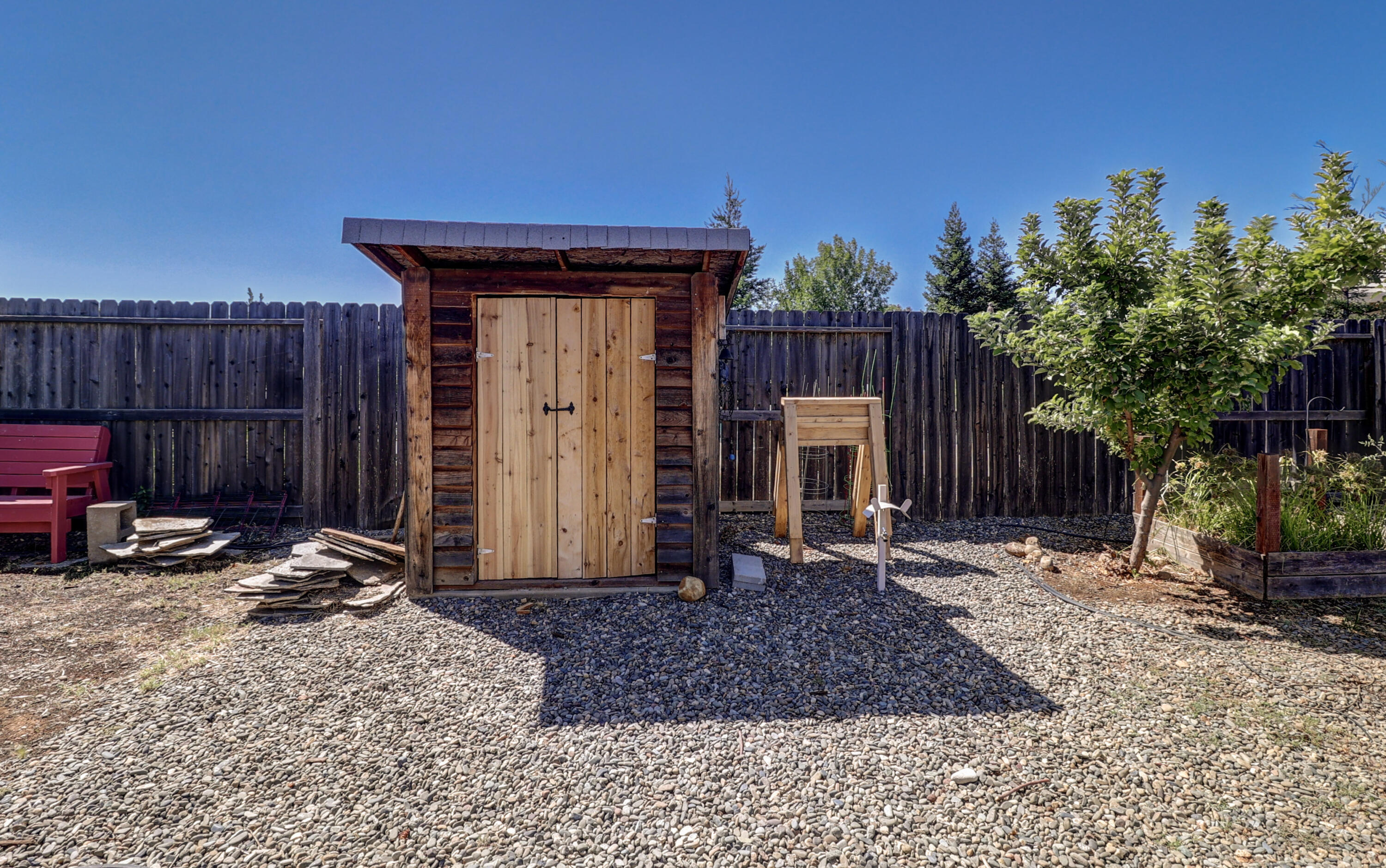 3863 Indian Wells Lane Redding, CA 96002 - Photo 57 of 63 a view of a backyard with a small cabin and chair