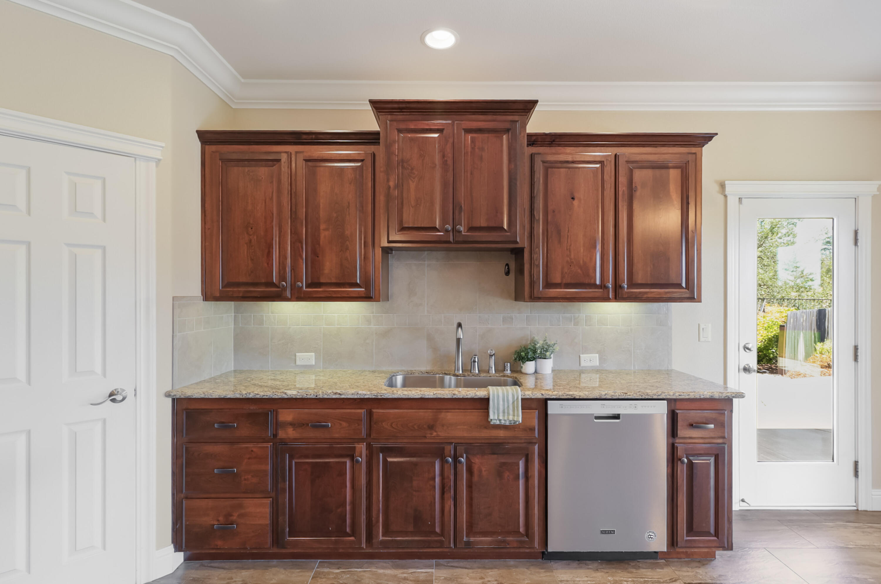 3863 Indian Wells Lane Redding, CA 96002 - Photo 9 of 63 a kitchen with stainless steel appliances granite countertop wooden cabinets a sink and dishwasher