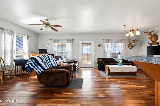 a living room with furniture chandelier and a wooden floor
