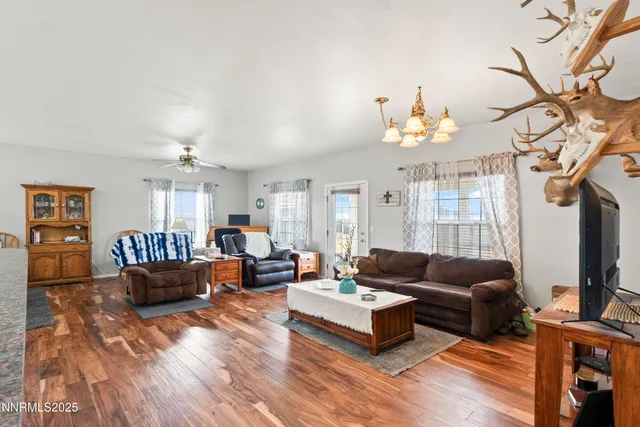 a living room with furniture a chandelier and a flat screen tv