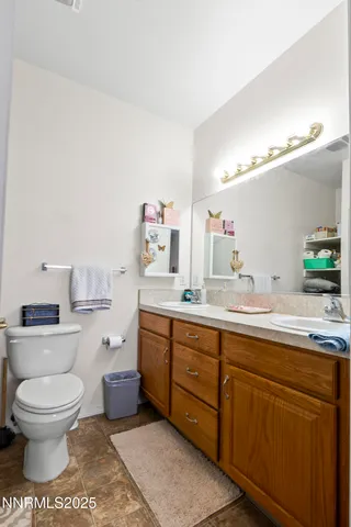 a spacious bathroom with a toilet a sink and a mirror