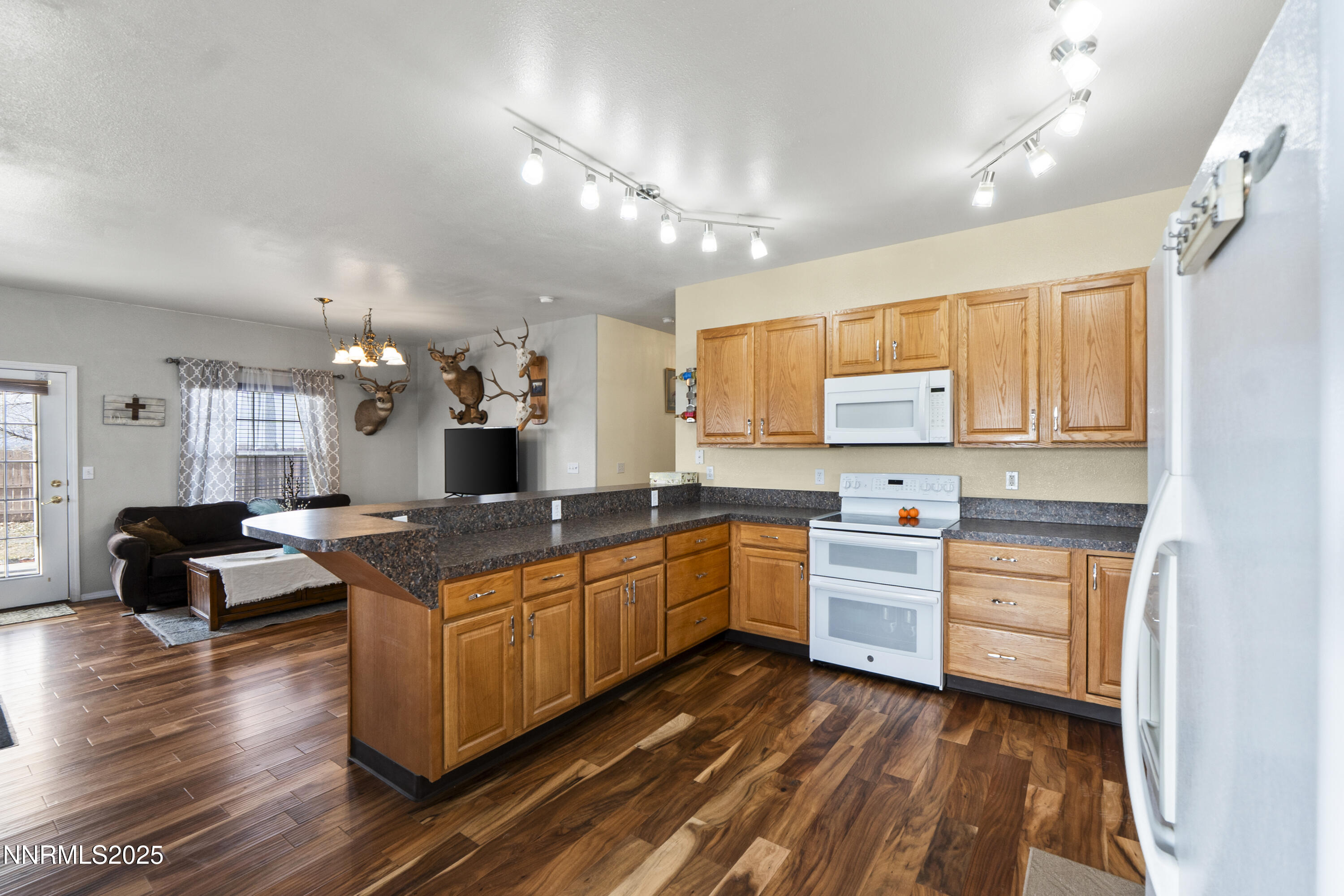 6990 Airport Road Winnemucca, NV 89445 - Photo 7 of 47 a large kitchen with kitchen island a stove a sink dishwasher a dining table and chairs with wooden floor