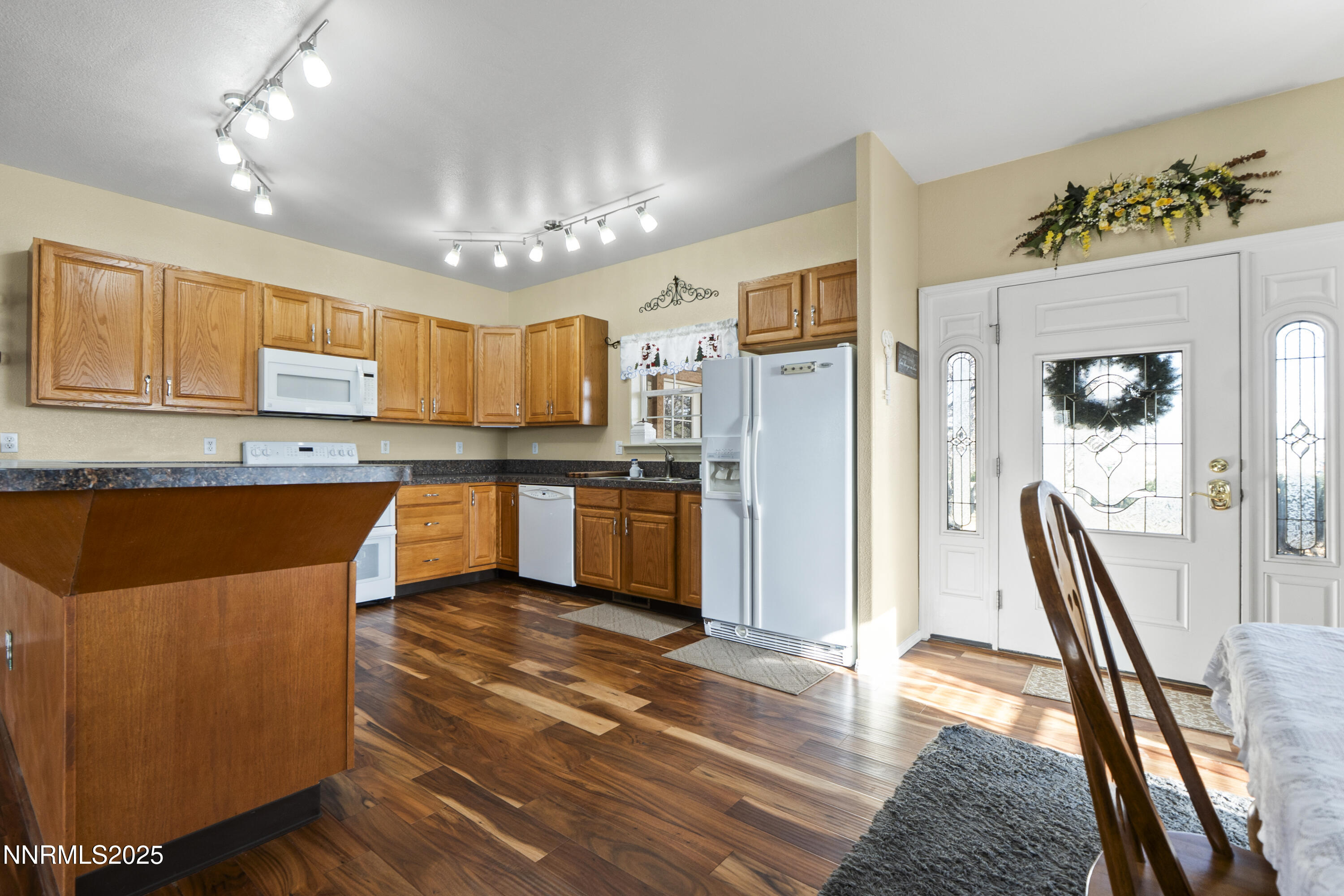 6990 Airport Road Winnemucca, NV 89445 - Photo 9 of 47 a kitchen with stainless steel appliances granite countertop a refrigerator a sink dishwasher and white cabinets with wooden floor