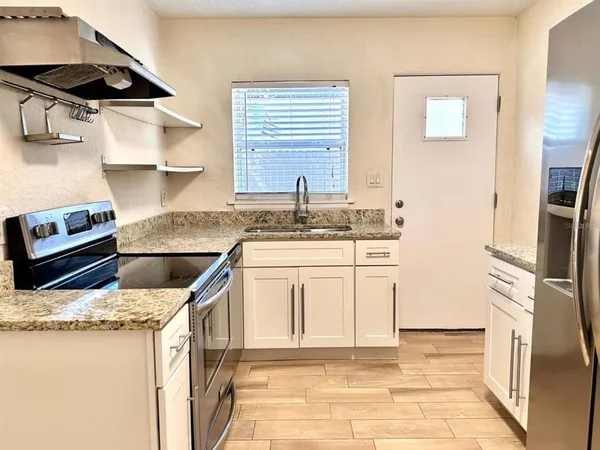 a kitchen with stainless steel appliances granite countertop a sink stove and refrigerator